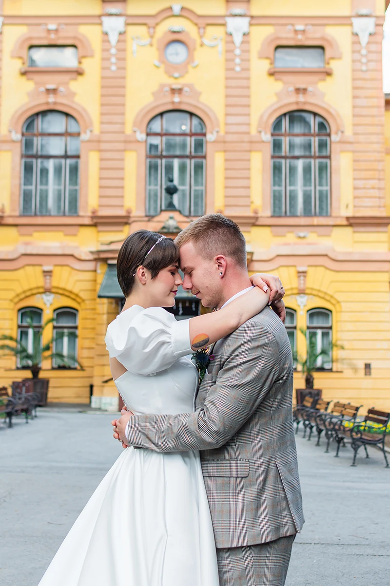 Romantický svadobný portrét páru pred historickou budovou v Bardejovských Kúpeľoch